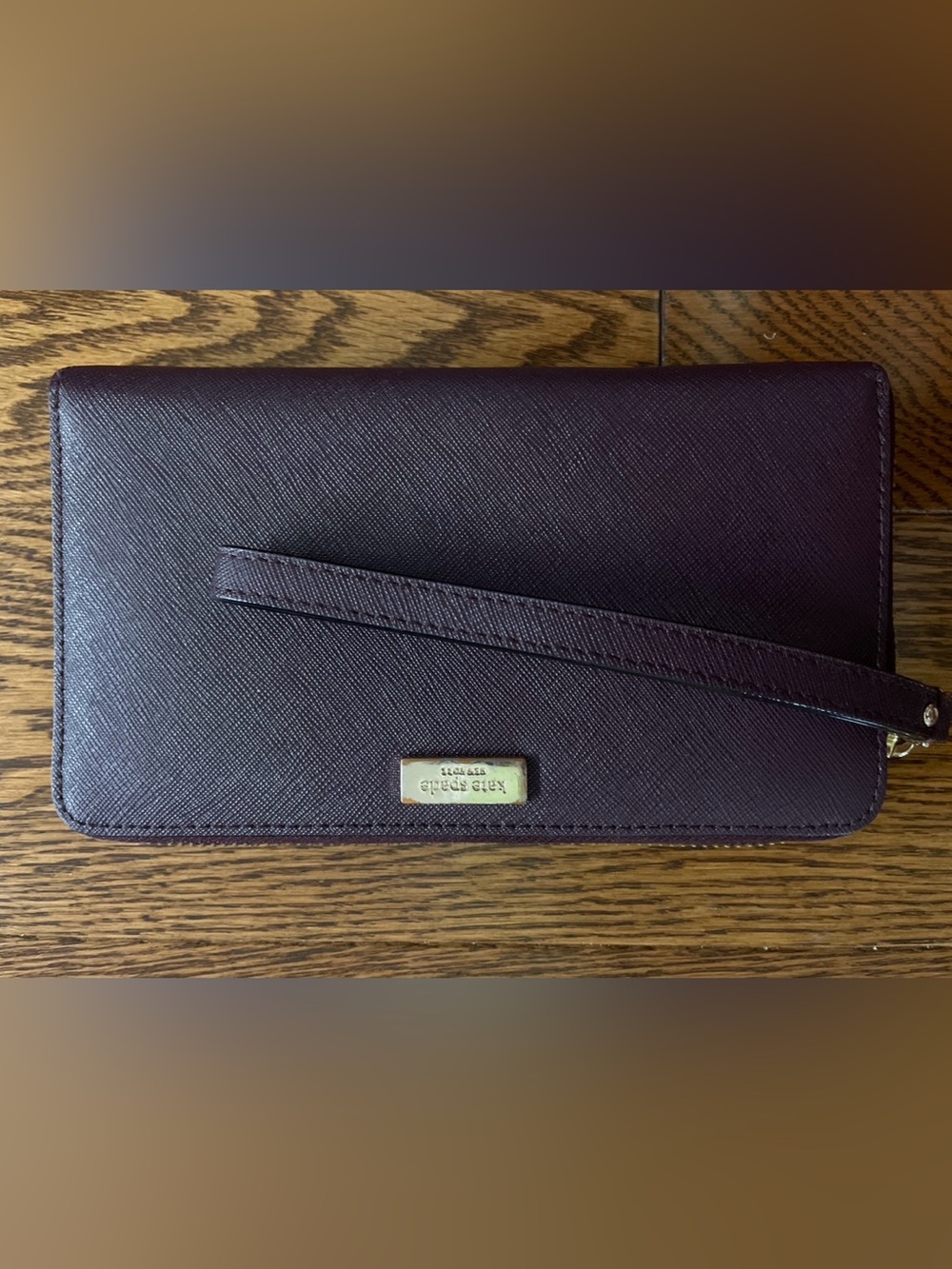 Kate Spade plum textured leather wristlet with gold plaque